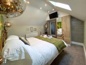 ein Schlafzimmer mit einem großen Bett und einem Spiegel in der Unterkunft Luxury tree-house with optional ESPA Spa in Canterbury