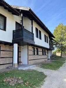une maison avec un balcon sur le côté de celle-ci dans l'établissement Къща за гости Геша Вю, à Dryanovo
