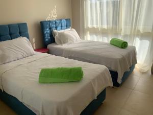 two beds with a green pillow on top of them at Elgouna Hurghada egypt mangroovy in Hurghada +39 photos
