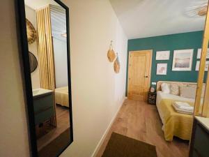 um espelho num quarto com uma cama e um quarto em Casa del palmar junior em Valência