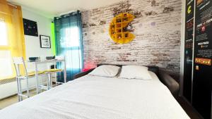 a bedroom with a bed and a brick wall at Appart Hotel Futuroscope 2 - Poitiers in Jaunay-Marigny