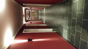 a long red corridor with a red floor and a wall at Hotel Crea in Adelboden