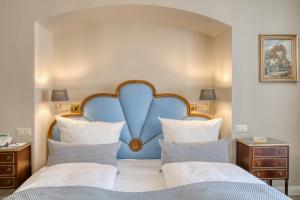a bedroom with a large bed with a blue headboard at Hotel Eisenhut in Rothenburg ob der Tauber