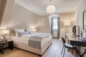 a bedroom with a bed and a desk with a computer at Hotel Eisenhut in Rothenburg ob der Tauber