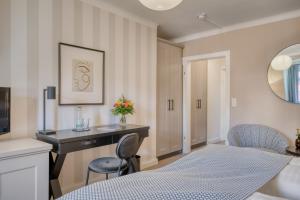a bedroom with a desk and chairs in a room at Hotel Eisenhut in Rothenburg ob der Tauber