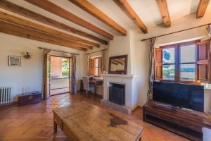 uma sala de estar com televisão e lareira em Cas Galgo luxury Villa in Valldemossa em Valldemossa