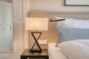 a lamp sitting on a table next to a bed at Hotel Eisenhut in Rothenburg ob der Tauber