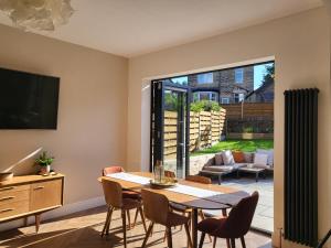 a dining room with a table and chairs and a television at Luxury 4 Bed Family property in popular location in Sheffield