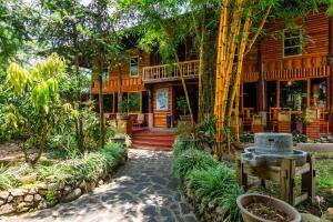 a wooden house with a walkway in front of it at Sapa Riverside Ecolodge & Spa in Sa Pa