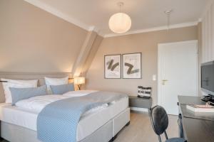 a bedroom with a bed and a desk and a tv at Hotel Eisenhut in Rothenburg ob der Tauber