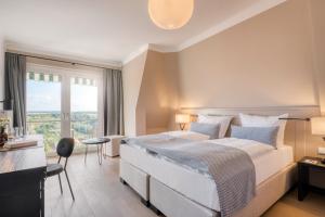 a bedroom with a large bed and a large window at Hotel Eisenhut in Rothenburg ob der Tauber