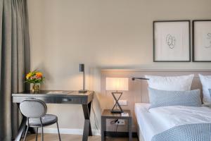 a bedroom with a desk and a bed and a desk with a chair at Hotel Eisenhut in Rothenburg ob der Tauber