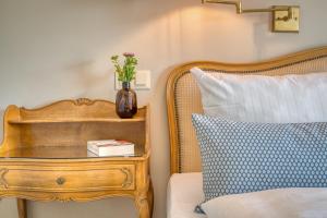 a vase of flowers on a table next to a bed at Hotel Eisenhut in Rothenburg ob der Tauber