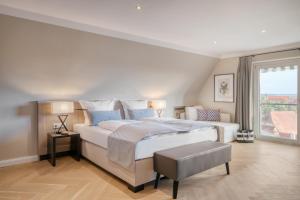 a bedroom with a large bed and a large window at Hotel Eisenhut in Rothenburg ob der Tauber