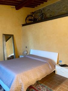 a bedroom with a bed and a bike on the wall at Room in BB - Sottotono Agriturismo with swimming pool on Florence surrounded by greenery in Carmignano