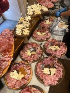 a bunch of pizzas on a table with cheese and meat at Room in BB - Sottotono Agriturismo with swimming pool on Florence surrounded by greenery in Carmignano