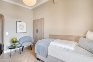 a bedroom with a bed and a table and a chair at Hotel Eisenhut in Rothenburg ob der Tauber