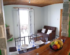a living room with a table with a bowl of fruit on it at Xigia hideaway - panoramic sea view house in Zakynthos Town