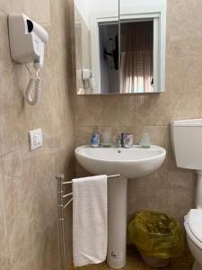 W łazience znajduje się umywalka, toaleta i lustro. w obiekcie Erythrà Bed and Breakfast w mieście Reggio di Calabria