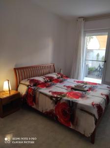 Un dormitorio con una cama con flores rojas. en Casa Giò, en Assemini