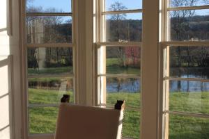 a window with a chair looking out at a view at St Marys Farmhouse - Traditional Country Farmhouse with Open Fire in Fochabers