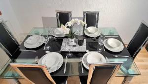 a dining room table with plates and glasses and flowers at Parkway in London Colney