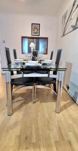 a dining room table with chairs and a glass top at Parkway in London Colney