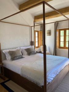 a bedroom with a large bed with a wooden frame at Magnifique villa dans propriété au havre de paix in Le Plan-de-la-Tour