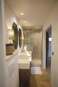 een badkamer met 2 wastafels en een douche met spiegels bij Magnifique villa dans propriété au havre de paix in Plan-de-la-Tour