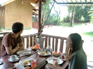 a man and woman sitting at a table eating food at Saffron Eco Cottage in Ella +31 photos