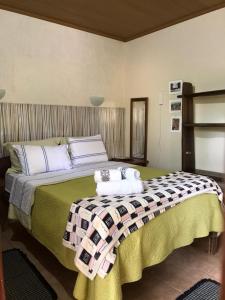 a bedroom with a large bed with a checkered blanket at Pousada Casa do Cerrado - Alto Paraíso de Goiás in Alto Paraíso de Goiás