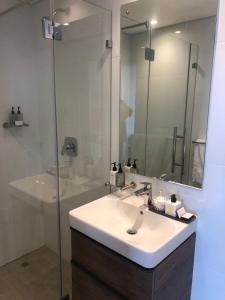 a bathroom with a sink and a shower with a mirror at Beachfront Suite Ocean-View Balcony 300Mb Fibre in Durban +52 photos