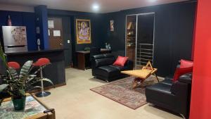 ein Wohnzimmer mit schwarzen Ledersesseln und roten Kissen in der Unterkunft Apartamento amoblado nuevo in Pereira