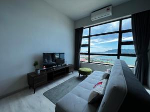 ein Wohnzimmer mit einem Sofa und einem großen Fenster in der Unterkunft Dreams Suites II, Jesselton Quay in Kota Kinabalu