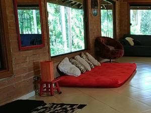 a red couch in a room with windows at Pousada Contempla Joanópolis in Joanópolis