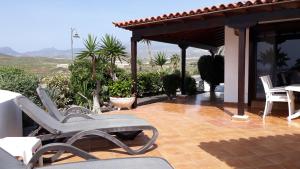 a patio with two chairs and a table on a house at La Quinta Villas in San Miguel de Abona
