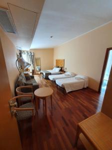 una camera d'albergo con due letti e un tavolo di Riviera Hotel a Enna