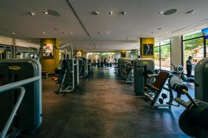 a gym with rows of machines and people in it at Fabulous 1 bedroom apartment at 5 Star Resort in Dubai