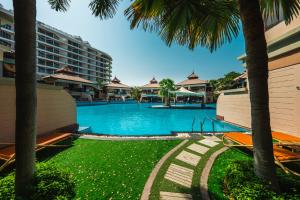 een zwembad met palmbomen en een hotel bij Fabulous 1 bedroom apartment at 5 Star Resort in Dubai