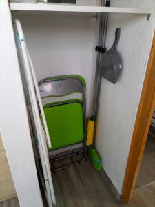 une chambre avec un balai et une valise verte dans l'établissement El Sueño: un lugar especial para sus vacaciones, à Fuencaliente de la Palma