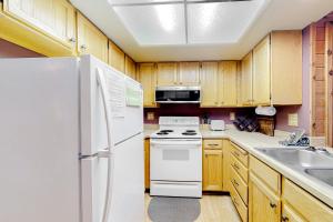 a kitchen with a white refrigerator and a sink at Chalet Village #24 in Brian Head