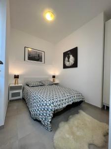 - une chambre avec un lit, une couette et un tapis dans l'établissement le petit sémaphore, à Saint-Raphaël