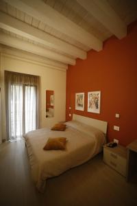 una camera con un grande letto con una parete arancione di The Garden a Canistro