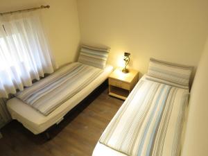 a bedroom with two beds and a lamp on a night stand at Baita Li Selucia in Livigno