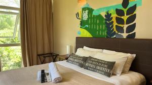 a bedroom with a bed with a large painting on the wall at Beer Hotel Iguazú in Puerto Iguazú