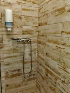 a bathroom with a shower with a wooden wall at Stay In Tmisoara in Timişoara