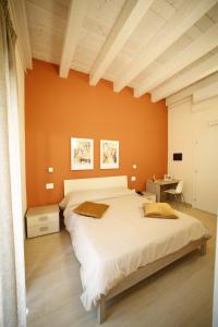 ein Schlafzimmer mit orangefarbenen Wänden und einem großen Bett in der Unterkunft The Garden in Canistro