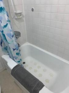 a bathroom with a bath tub with a shower curtain at Ocean and Mountain View Condo - Free Reserved Parking in Honolulu