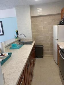 a kitchen with a sink and a refrigerator at Ocean and Mountain View Condo - Free Reserved Parking in Honolulu