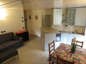 a kitchen and living room with a table and a couch at Baita Li Selucia in Livigno +5 photos